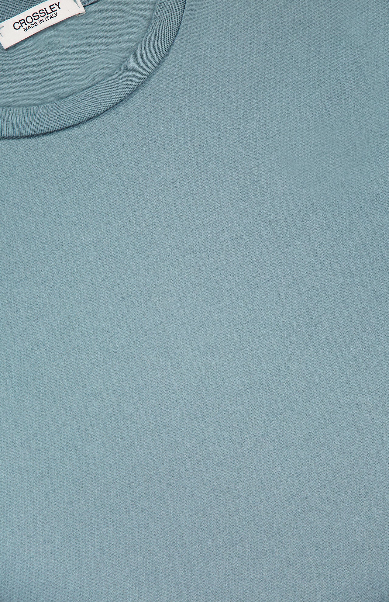 Close-up of the Hunt Cotton Short Sleeve Crew T-shirt by CROSSLEY in light blue, laid flat to show the upper chest and neckline. The white tag displays CROSSLEY and MADE IN ITALY, highlighting its quality Italian craftsmanship.