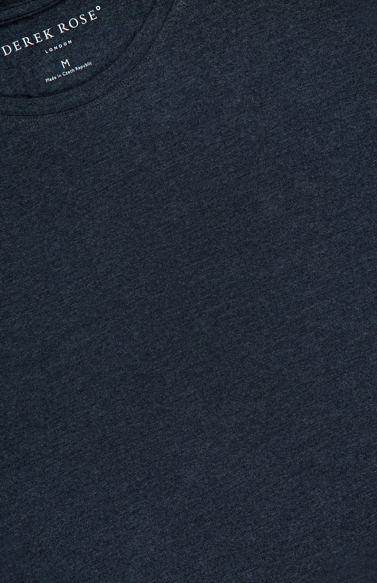 Close-up of a dark navy blue DEREK ROSE Ethan Micro Modal Stretch T-shirt, featuring its breathable micro modal blend, with the neckline and chest area shown and the brand logo plus size printed inside the collar.