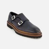 The DI BIANCO Mezzaro Bisonte Loafer is a single navy double monk dress shoe crafted from bison leather, featuring two silver buckle straps and a brown sole, displayed on a light background.