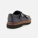 The Mezzaro Bisonte Loafer by DI BIANCO is a dark blue bison leather double monk dress shoe featuring two silver buckles and a thick brown sole, displayed from a rear-side angle against a plain white background.