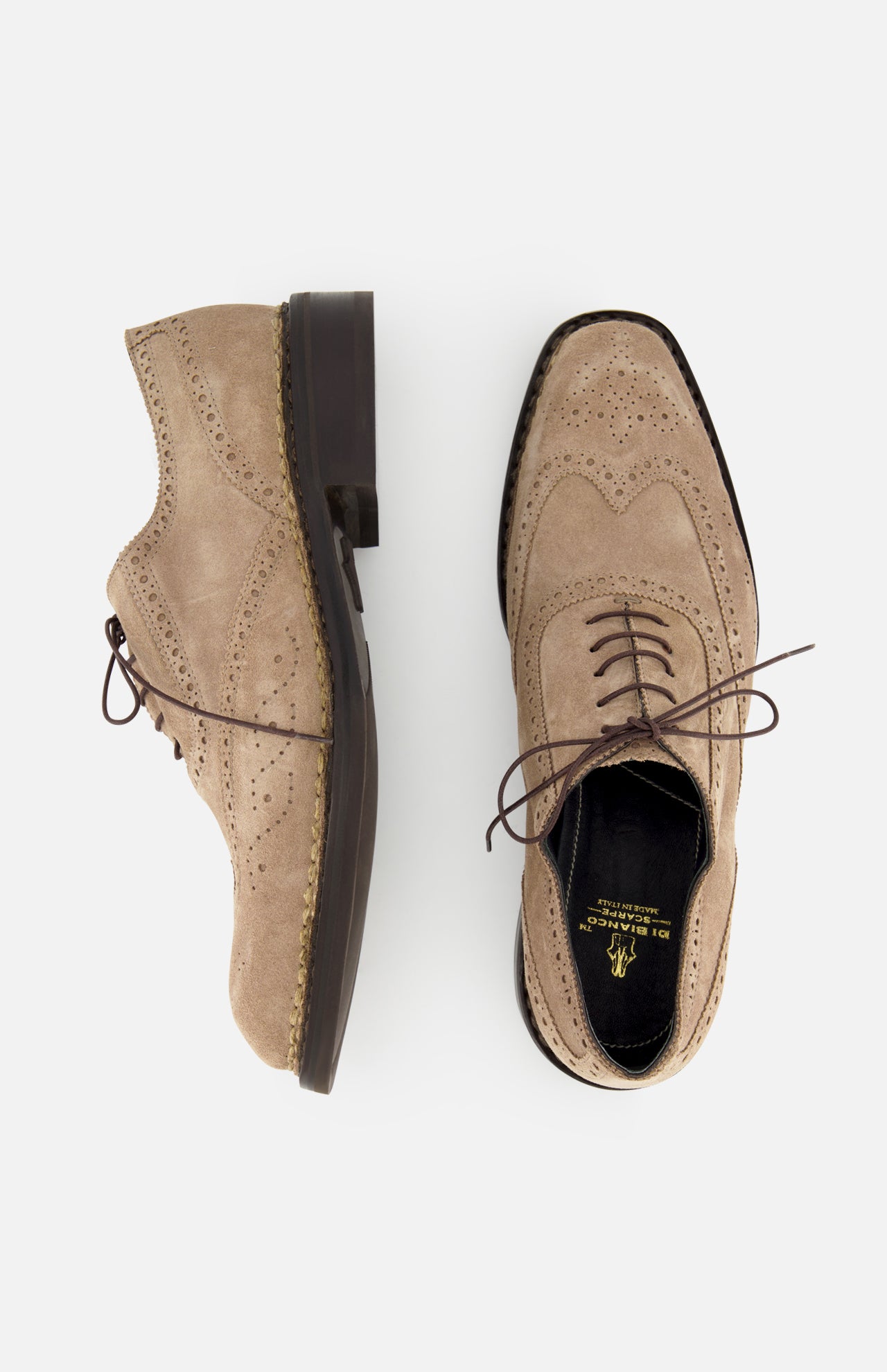 The DI BIANCO Nettuno Suede Lace Up Loafer—a pair of beige dress shoes with wingtip brogue Oxford detailing, brown laces, and decorative perforations—displayed from the side and above on a light background.