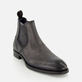 The Osimo Peccary Boot by DI BIANCO is a dark gray grained leather Chelsea boot with a subtle shine, elastic side panels, and a fabric pull tab at the back, shown on a white background.