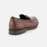 The DI BIANCO Tombolo California Slip On Loafer is displayed from the back at an angle on a white background, showcasing its brown leather, penny strap, and visible stitching details. Made in Italy.