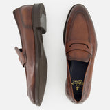 Two Tombolo California Slip On Loafers by DI BIANCO, shown in brown leather on a white background—one from the side, one from above—highlight stitching details and the classic slip-on loafer style. Made in Italy.