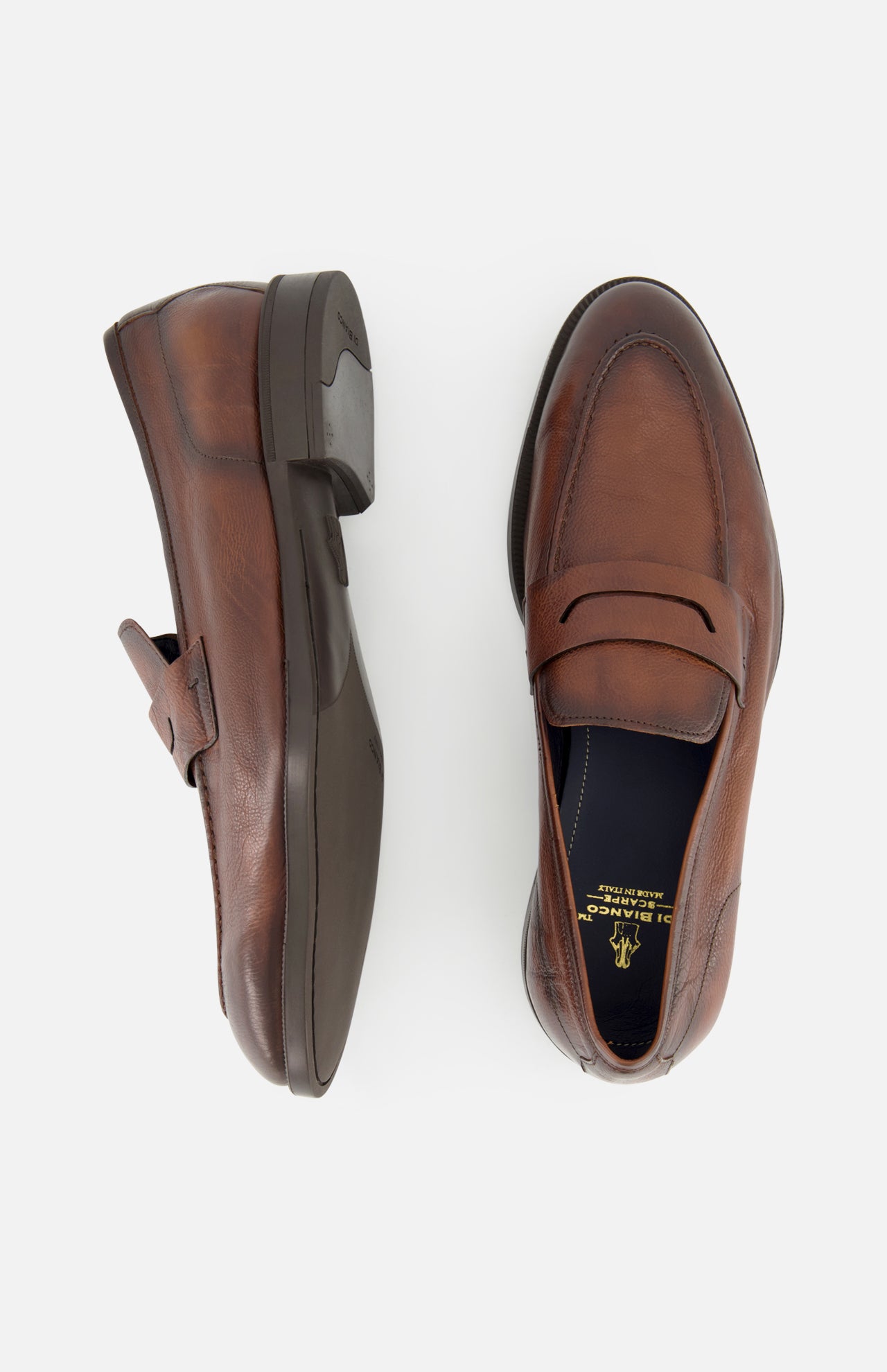 Two Tombolo California Slip On Loafers by DI BIANCO, shown in brown leather on a white background—one from the side, one from above—highlight stitching details and the classic slip-on loafer style. Made in Italy.