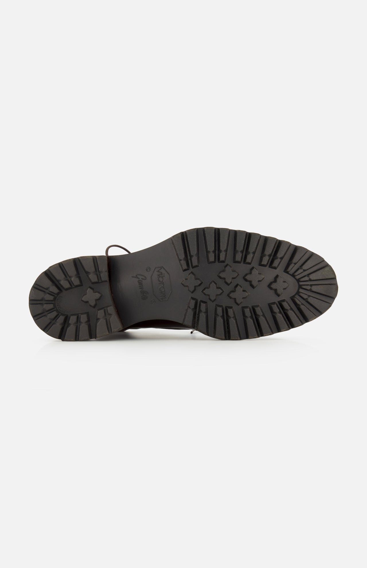 The image shows the bottom view of the DI BIANCO Torino Calfskin Suede Boot, featuring a black sole with deep, rugged treads and a central logo, reminiscent of military-style boots and designed for enhanced grip and durability.