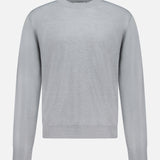 The Libeccio Wren Crewneck Sweater by ELDER STATESMAN is a light gray, luxury knitwear piece featuring long sleeves and a classic crew neck. Displayed on a plain white background, this sweater boasts refined ribbing at the collar, cuffs, and hem. Expertly crafted from a premium wool, silk, and linen blend, it combines exceptional comfort with timeless elegance for effortless style.