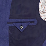 Close-up of the inside pocket of the ZEGNA Cashmere Silk Linen Sportcoat in dark blue, showing a blue herringbone fabric, dark pocket flap button, and striped lining. Expertly crafted in Italy for refined style.