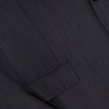 Close-up of the ZEGNA 15MilMil15 Wool Suit jacket in dark grey, made in Italy, featuring a textured fine-patterned fabric, a flap pocket, part of the lapel, and a single button.
