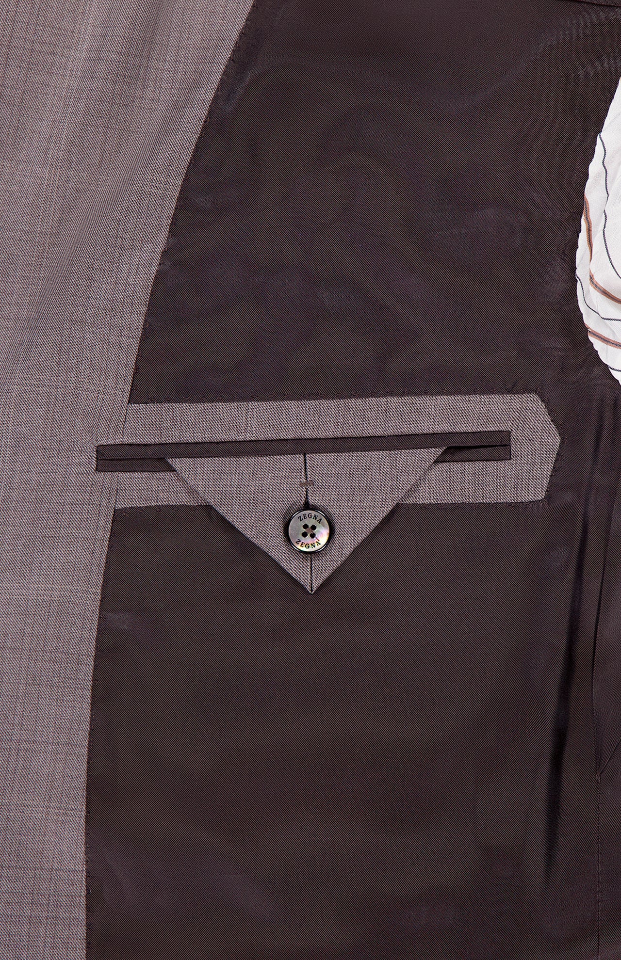 Close-up of the inside pocket of the ZEGNA 15MilMil15 Wool Suit, featuring a gray lining, triangular stitched flap, and single button closure—showcasing expert Italian craftsmanship.