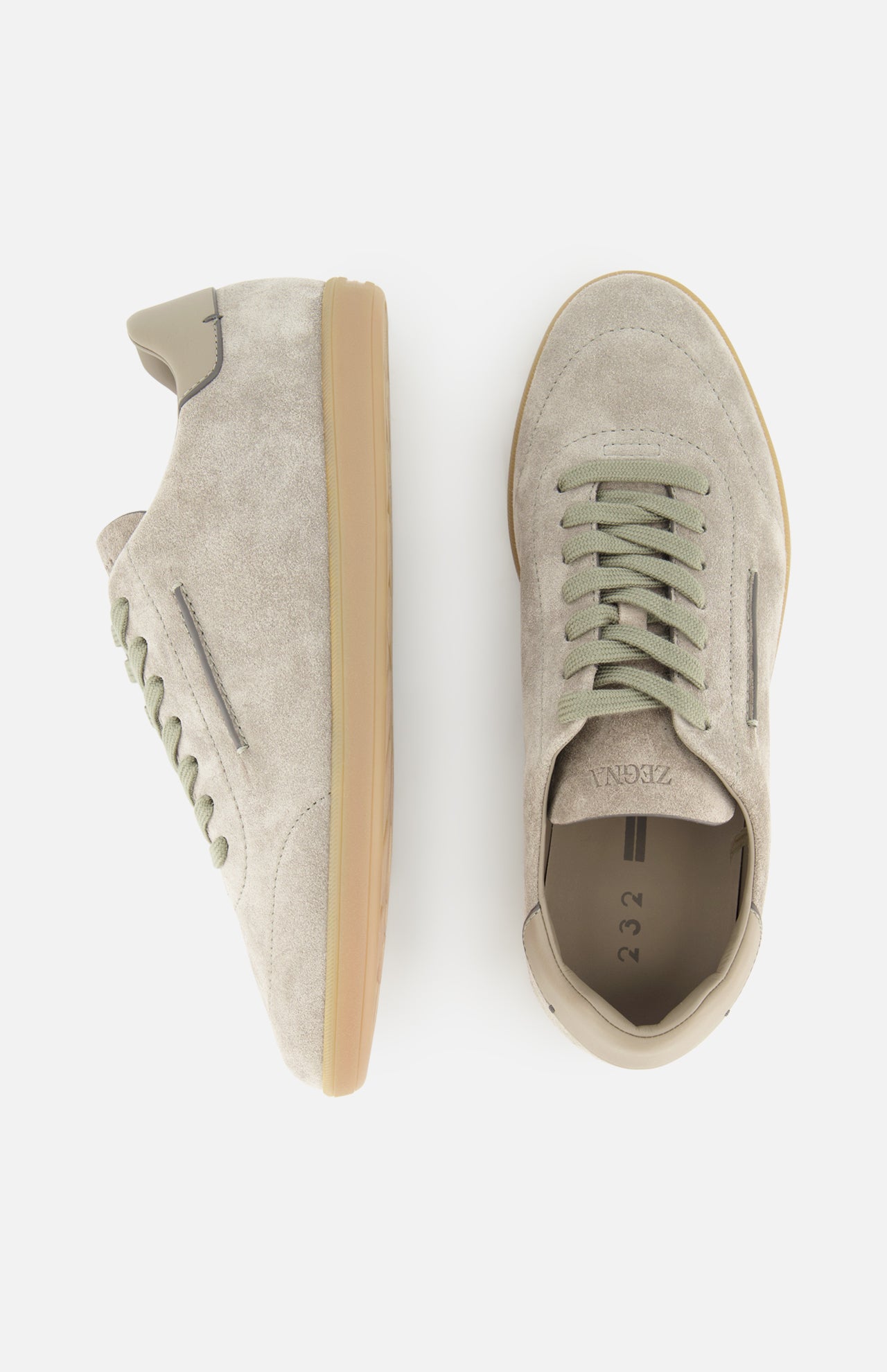 A pair of ZEGNA 232 Low Top Sneakers in beige and light grey suede, featuring light green laces and tan rubber soles, is displayed from a side view (left shoe) and a top view (right shoe) against a white background. Expertly crafted in Italy, these refined sneakers offer the perfect combination of comfort and contemporary design.