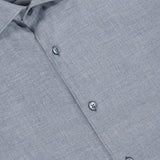 Close-up of the ZEGNA Cashco Dress Shirt in light grey textured fabric, showcasing a pointed collar and three visible buttons. The black label features “ZEGNA” and “Como” in white text, emphasizing this refined cashmere-cotton shirt crafted in Italy.