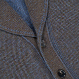 Close-up of the ZEGNA Cashmere & Wool Cardigan Sweater, featuring a textured brown and blue knit with two dark buttons, blue stitching along the seams, and a classic shawl collar.