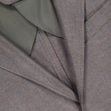 Close-up of a neatly folded ZEGNA Detachable Knit Bib Sportcoat, showcasing its sleek design, signature label, dark button, and a hint of olive green lining.
