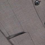 Close-up of the ZEGNA Detachable Knit Bib Sportcoat, a men's luxury blazer in brown tweed with a welt pocket, lapel detail, button accent, and textured fabric featuring subtle blue and red threads.