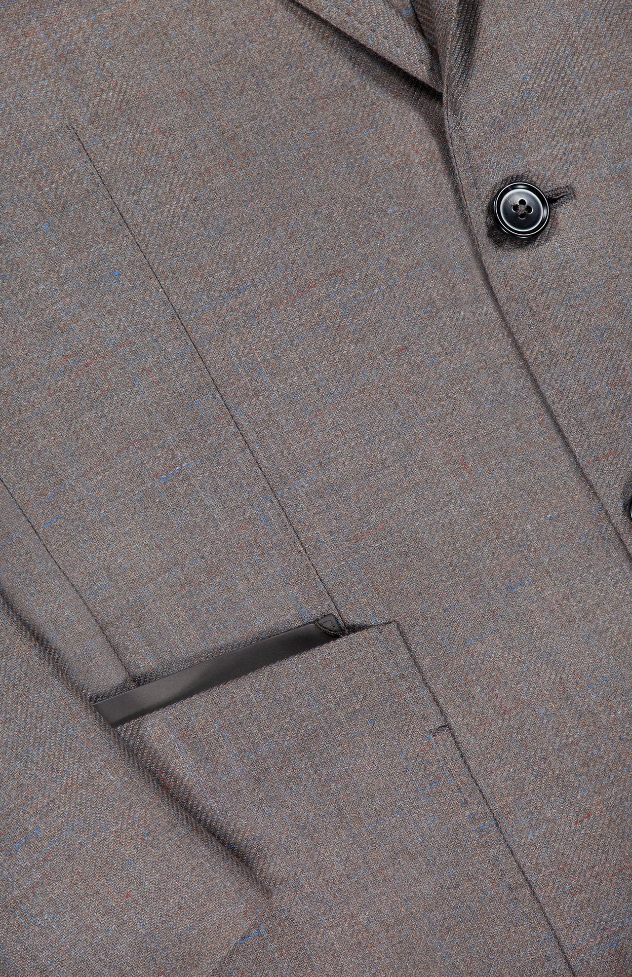 Close-up of the ZEGNA Detachable Knit Bib Sportcoat, a men's luxury blazer in brown tweed with a welt pocket, lapel detail, button accent, and textured fabric featuring subtle blue and red threads.