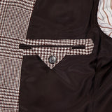 Close-up of the ZEGNA Houndstooth Plaid Linen-blend Sportcoat’s interior, featuring a buttoned pocket, brown lining, and brown-and-white striped fabric—a classic detail for any men's professional wardrobe.
