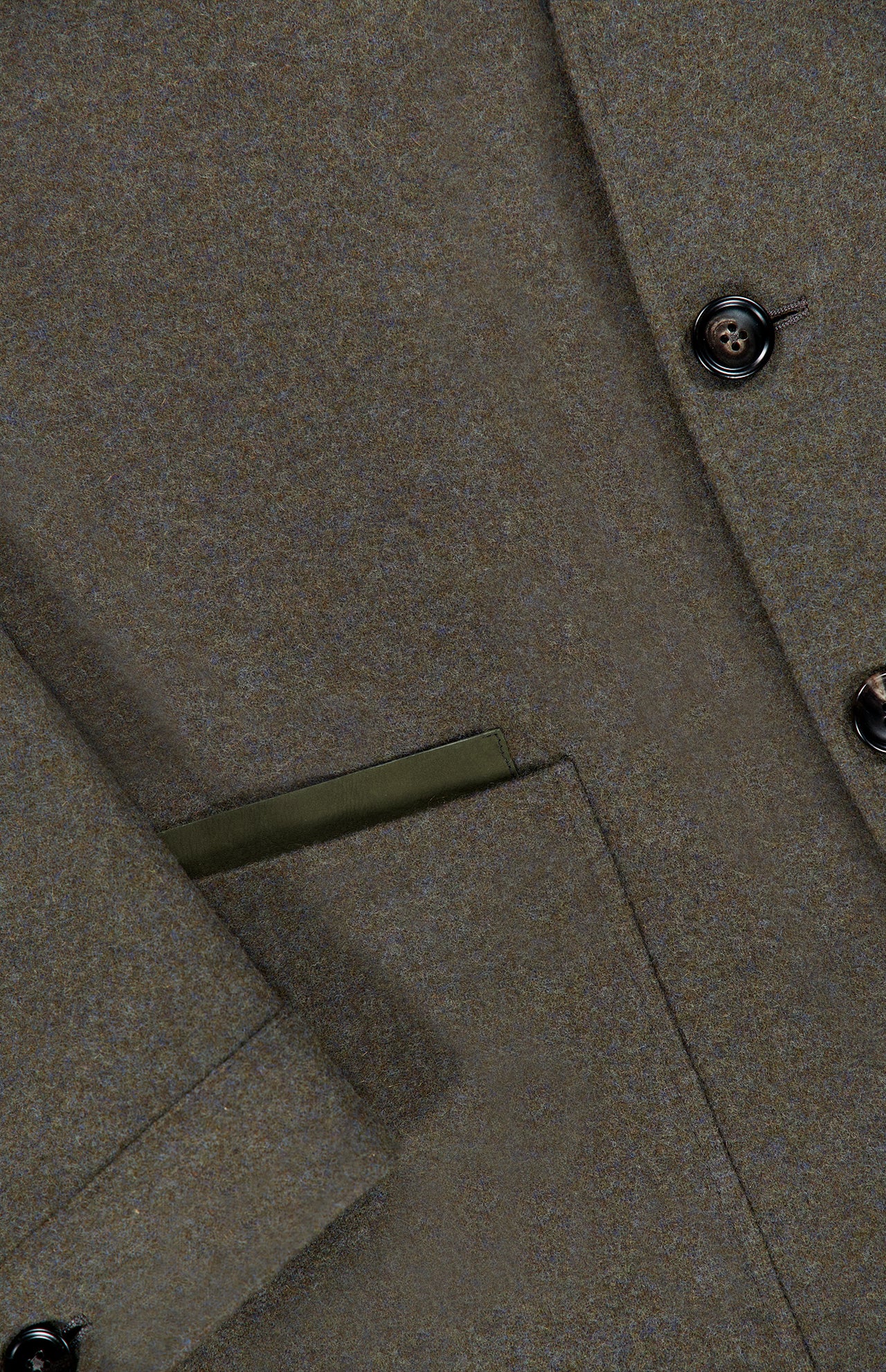 Close-up of the ZEGNA Jerseywear Chore Jacket in olive green wool-cashmere, highlighting a button, part of a flap pocket, and a neatly finished pocket edge with visible stitching. Inspired by the timeless Zegna 232 road, this piece merges classic tailoring with contemporary style.