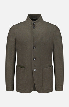 The ZEGNA Jerseywear Chore Jacket is crafted in olive green wool and features a stand collar, button-up front, and two spacious front pockets—one accented with a contrasting fabric trim. Reminiscent of a refined dark green chore jacket, this piece blends utilitarian design with elevated tailoring. The Jerseywear Chore Jacket is presented against a plain white background.