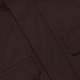 Close-up of the ZEGNA Microfiber Polyester Twill Field Jacket in dark brown, showcasing a buttoned collar, two front flap pockets, and clean tailored stitching.