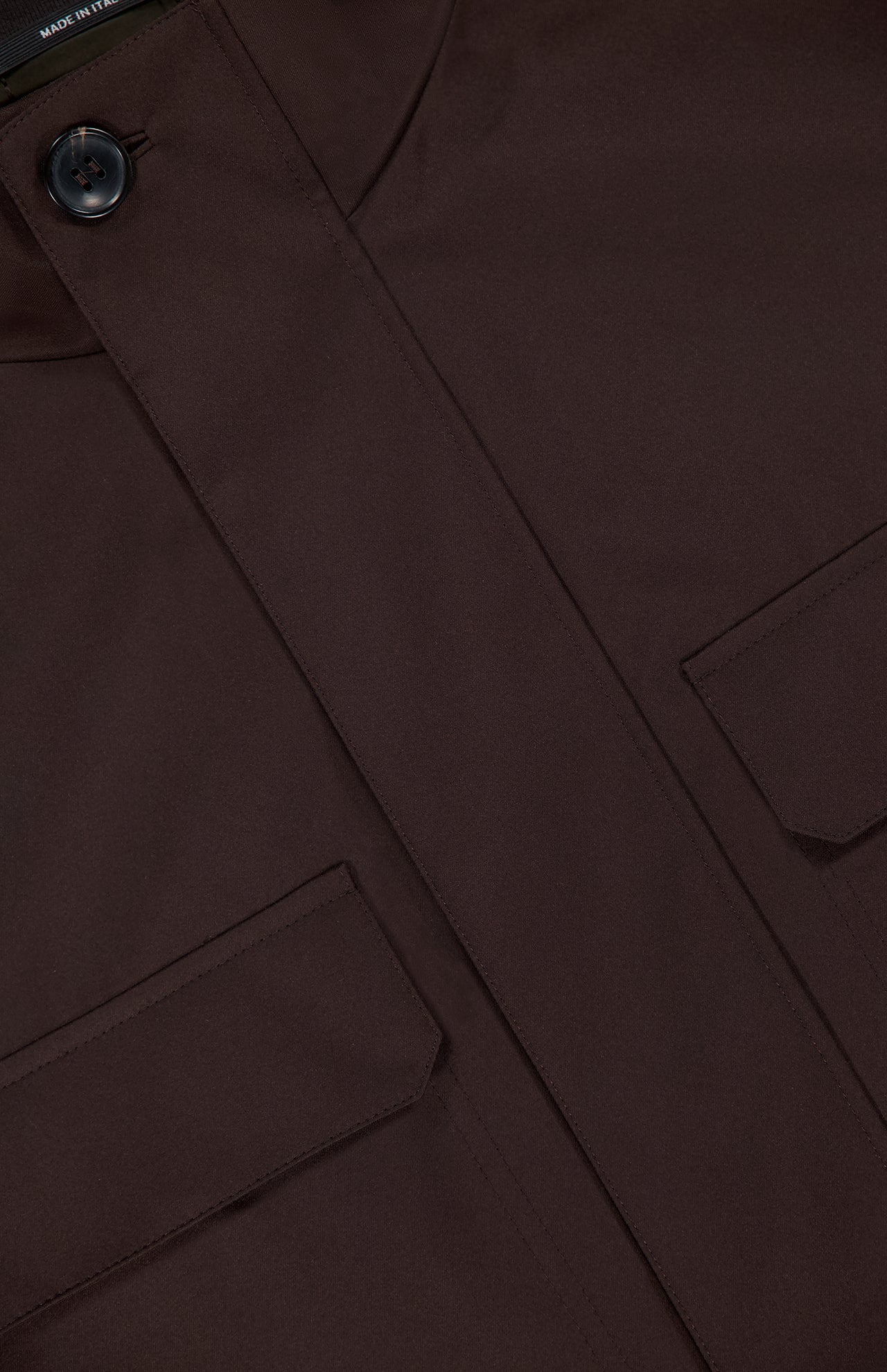 Close-up of the ZEGNA Microfiber Polyester Twill Field Jacket in dark brown, showcasing a buttoned collar, two front flap pockets, and clean tailored stitching.