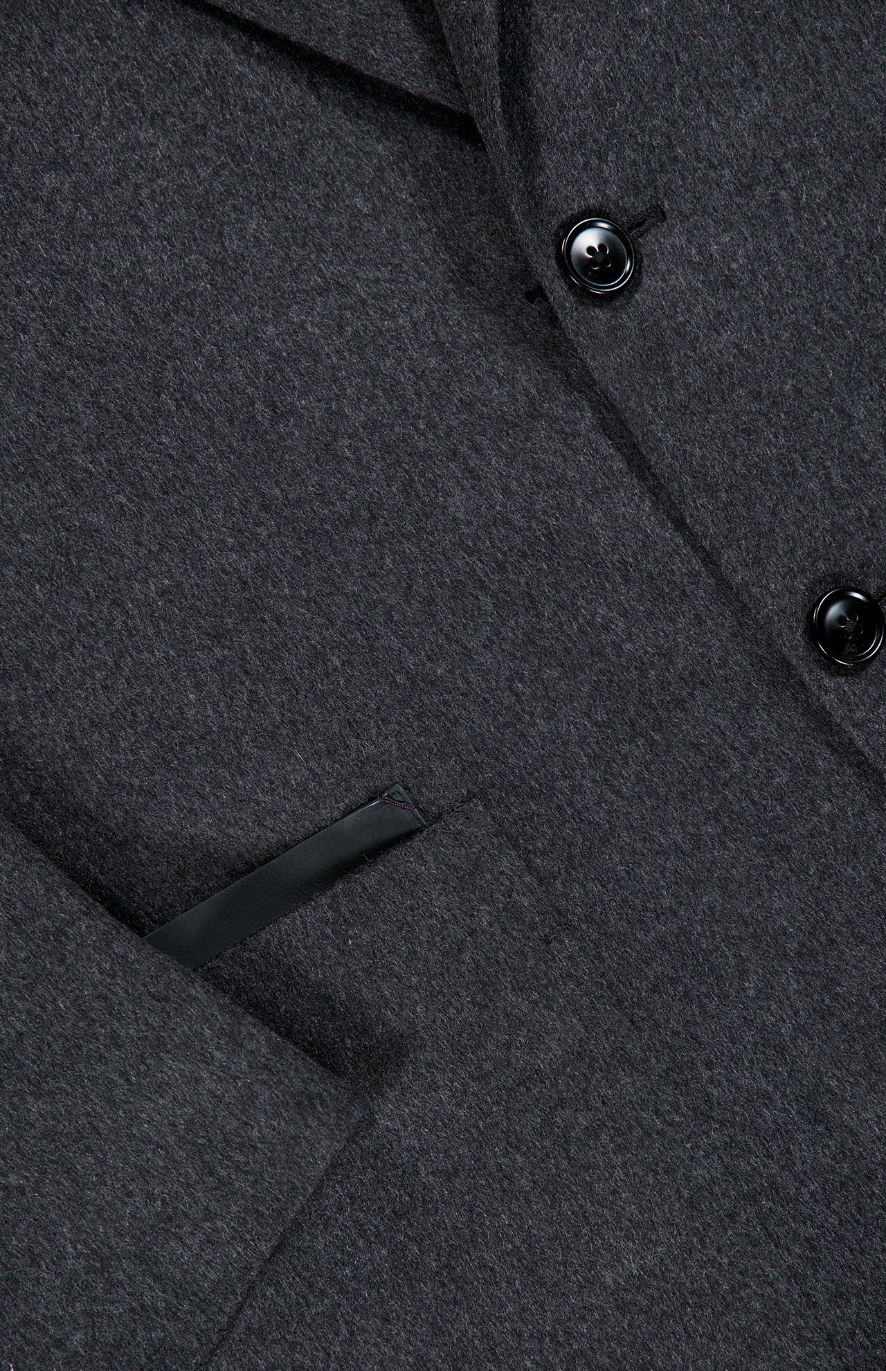 Close-up of the ZEGNA Oasi Cashmere Beaver Jacket, made in Italy in a dark gray cashmere, featuring black buttons, a sharp lapel, and a welt pocket accented with leather trim—an exquisite piece of luxury menswear.