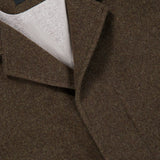Close-up of a brown Oasi Cashmere Jacket by ZEGNA, showing the Zegna label on the inside collar, notched lapel, and light beige inner lining.
