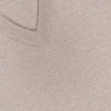 Close-up of the Oasi Cashmere V-Neck Sweater by ZEGNA in beige, highlighting its fine knit texture and featuring a black ZEGNA label at the upper left; this luxurious sweater is expertly crafted in Italy from premium cashmere.
