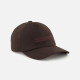 The ZEGNA Oasi Lino Lined Baseball Cap is a dark brown 100% linen cap featuring a curved brim and subtle horizontal stripe detail on the front, shown against a plain white background.