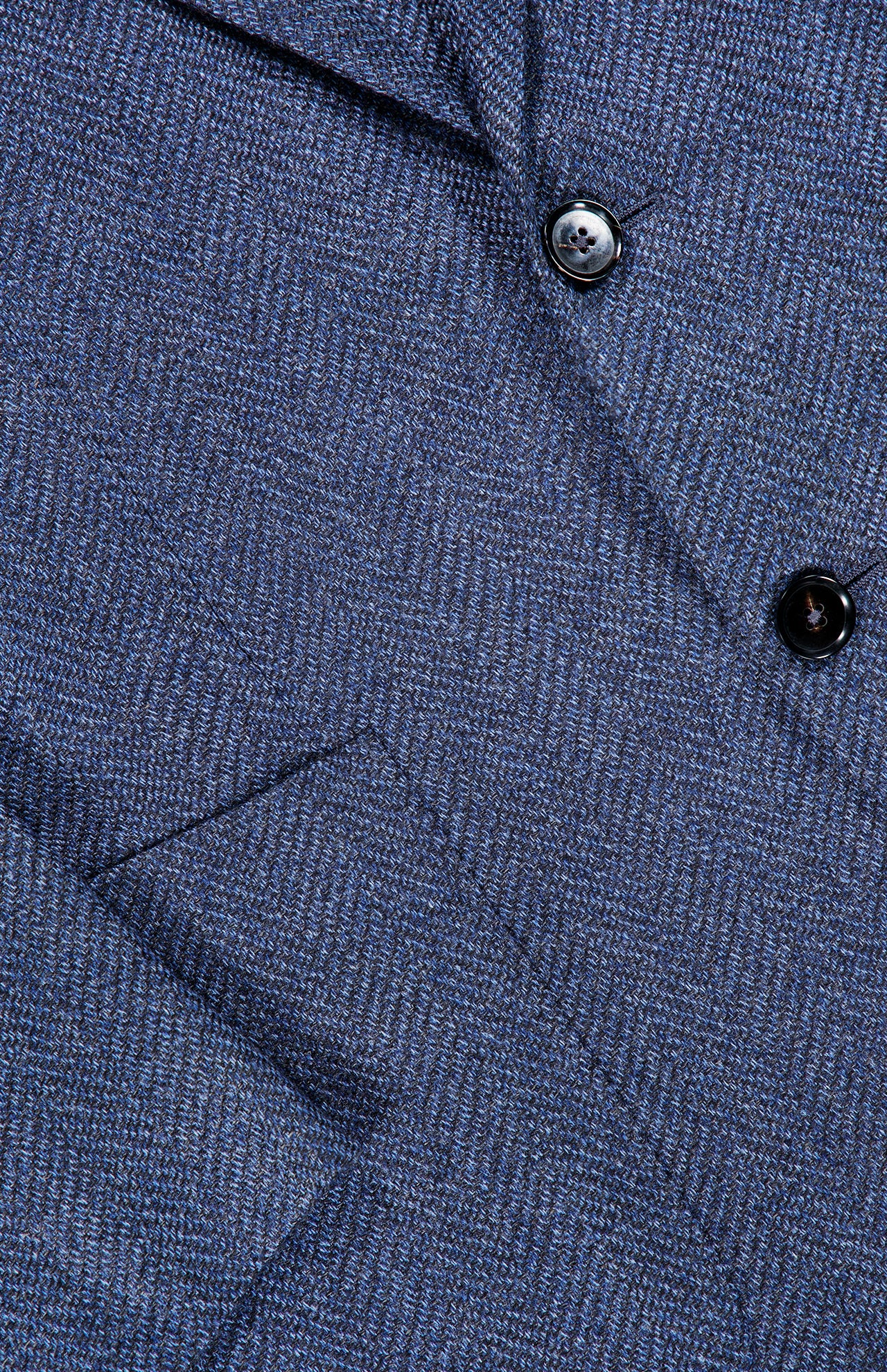 Close-up of the textured blue herringbone fabric of the ZEGNA Pure Cashmere Sportcoat, featuring two black buttons and a pocket detail.