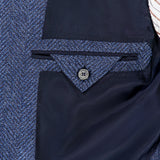 Close-up of the inside pocket of the ZEGNA Pure Cashmere Sportcoat in dark blue, tailored in classic tweed with a button closure and dark lining, shown next to a white and brown striped shirt.