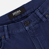 Close-up of the waistband and upper front of ZEGNA Pure Cotton Slim Fit Pants in dark blue, featuring belt loops, a button closure, 5-pocket design, and a black ZEGNA label sewn inside the waistband.
