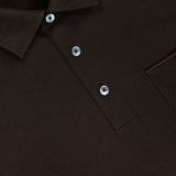A close-up of the ZEGNA Pure Cotton Piquet Short Sleeve Polo Shirt in dark brown, highlighting the collar, three buttons, part of the chest pocket, and the ZEGNA label at the neckline.