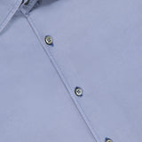 A close-up of the ZEGNA Pure Silk Dress Shirt in blue, featuring a visible brand label on the collar and three front buttons. The smooth fabric is neatly pressed and made in Italy.