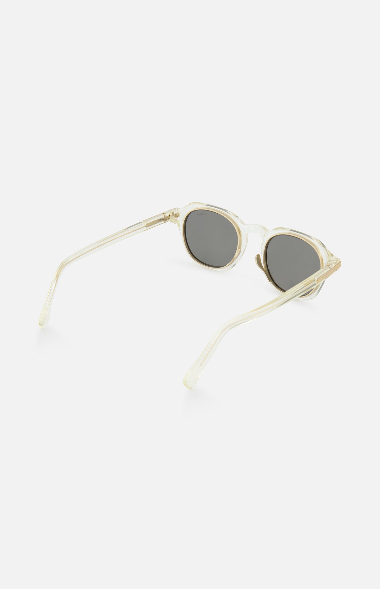 The ZEGNA Rounded Champagne Sunglasses feature a translucent, light beige champagne round frame with smoke lenses and slim transparent arms, shown from a side angle on a white background.