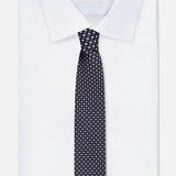 A neatly folded white dress shirt with a crisp collar is paired with the ZEGNA Silk Jacquard Tie, an elegant blue silk accessory made in Italy and detailed with a refined pattern of small, light-colored dots. The ensemble is presented against a plain white background.