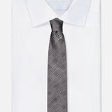 A neatly folded white dress shirt with a classic collar is paired with the ZEGNA Silk Jacquard Tie in grey and black, crafted in Italy, and displayed against a plain white background.