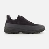 The ZEGNA Triple Stitch Low Top Sneaker is a black slip-on shoe with a rugged rubber sole and a durable leather and suede upper, displayed in side profile against a white background; this hiking-inspired sneaker offers the easy wear of a slip-on combined with lasting craftsmanship.