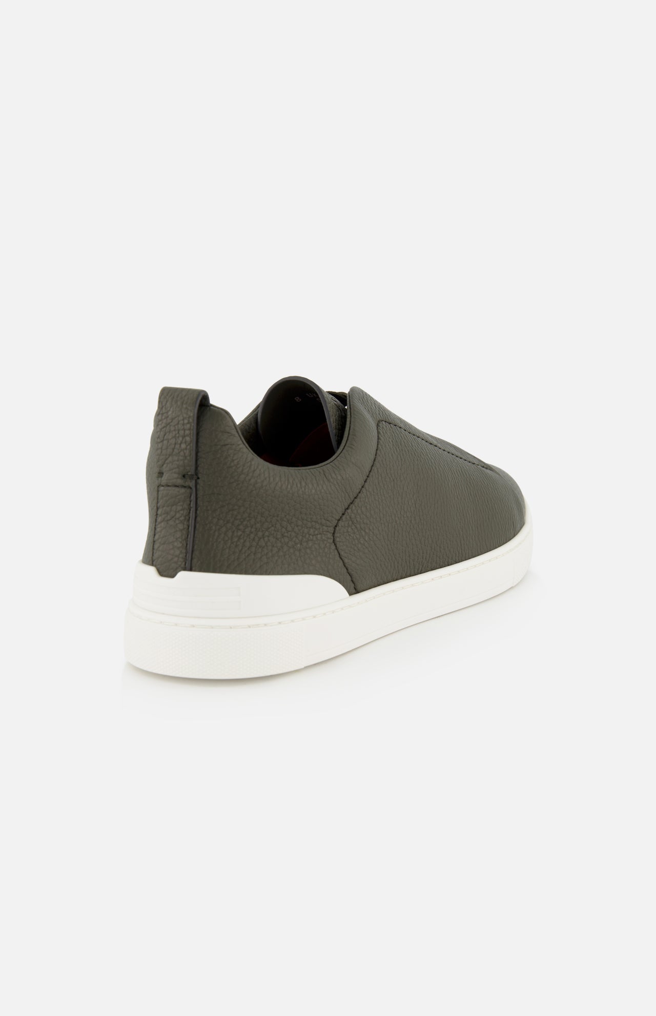 Rear three-quarter view of a ZEGNA Triple Stitch Low Top Sneaker in olive green suede with a thick white rubber sole.