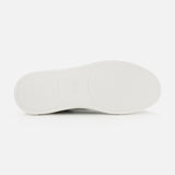 Flat white rubber sole of a ZEGNA Triple Stitch Low Top Sneaker, featuring a textured tread pattern and a logo at the center.