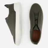ZEGNA Triple Stitch Low Top Sneakers in olive green suede, featuring a slip-on design with thick white rubber soles, shown from side and top views.