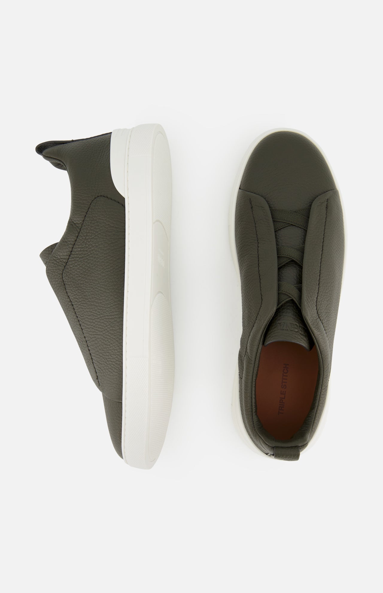 ZEGNA Triple Stitch Low Top Sneakers in olive green suede, featuring a slip-on design with thick white rubber soles, shown from side and top views.