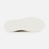 The image features the bottom view of a white ZEGNA Triple Stitch Low Top Sneaker sole set against a plain white background. The sole displays a subtle texture and gentle contouring for enhanced grip, showcasing the refined design characteristic of luxury casual footwear.