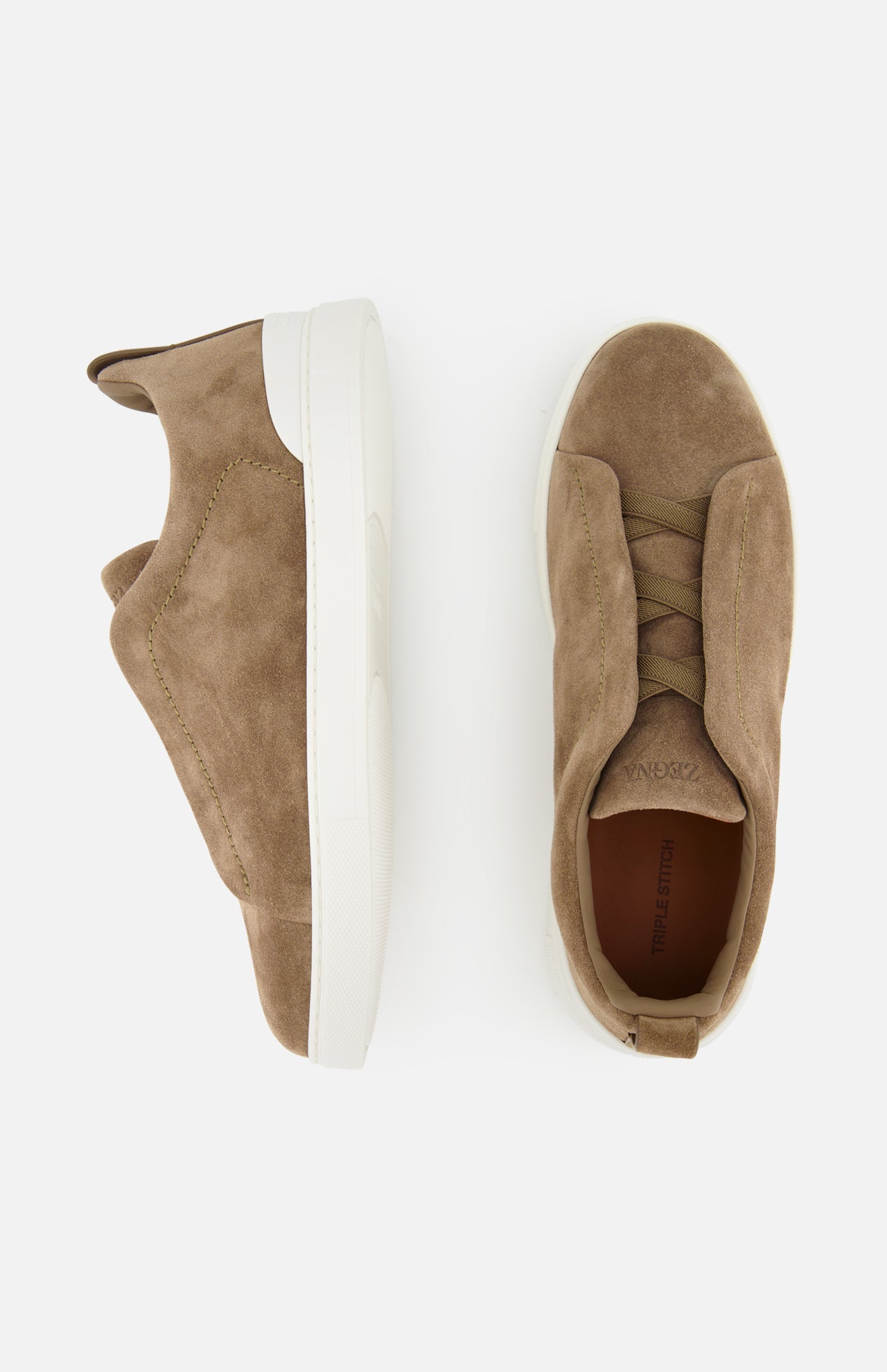 A pair of ZEGNA Triple Stitch Low Top Sneakers in taupe suede with white soles, displayed from the side and top views on a white background, exemplifies luxury casual footwear.
