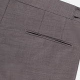 Close-up of ZEGNA Trofeo Wool Adjustable Tab Pants in brown slim fit, highlighting the waistband, belt loops, and single welt back pocket against a plain light background.