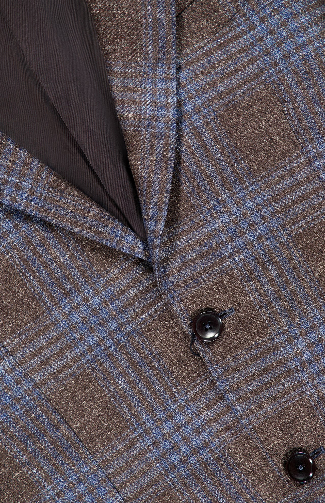 Close-up of the ZEGNA Wool Silk Linen Sportcoat, featuring a brown and blue plaid pattern, crafted from a luxurious blend of wool, silk, and linen. The image highlights two dark buttons, a visible lapel, and part of the dark inner lining.