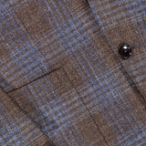 Close-up of the ZEGNA Wool Silk Linen Sportcoat, featuring a brown and blue plaid pattern, crafted from a luxurious wool-silk-linen blend, with black buttons and part of the front pocket visible.