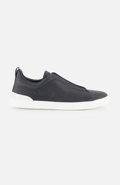 ZEGNA Triple Stitch Sneakers in navy blue smooth leather, featuring a laceless design and white rubber sole, photographed on a plain white background.