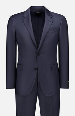 The ZEGNA Trofeo Milano Suit Navy is a men's two-piece suit made in Italy from 100% wool, featuring a tailored blazer with notch lapels, two buttons, front flap pockets, and matching trousers, shown on a white background.