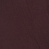 A close-up view of the ETERNE Long Sleeve Turtleneck Maxi Dress shows its plain dark maroon jersey modal blend fabric, highlighting subtle creases and texture.